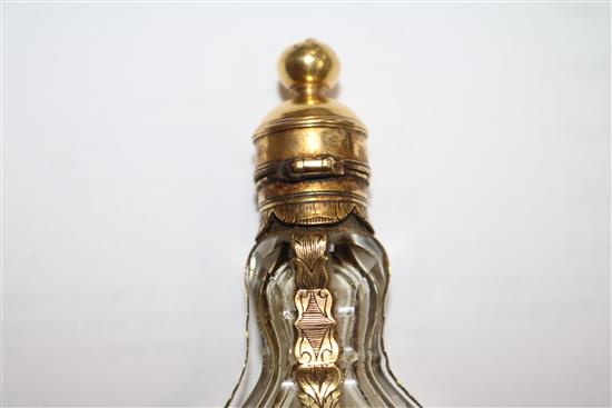 A late 18th century French yellow metal mounted glass scent bottle, with pierced removable finial.